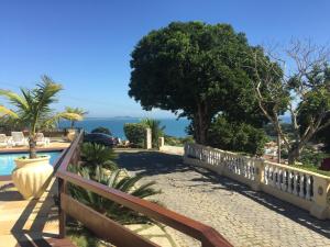 a fence next to a pool with a view of the ocean at Barlavento Suites in Búzios