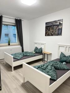 two beds in a room with a window at Stilvolles Apartment Royal Zentral Ruhig & Parkplatz inkl in Gelsenkirchen