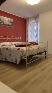 a bedroom with a bed and a red wall at ROSALINDA - Borgo Experience Cilento in Casaletto Spartano