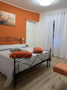 a bedroom with a bed with an orange wall at ROSALINDA - Borgo Experience Cilento in Casaletto Spartano