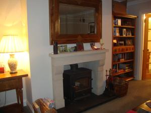 a living room with a fireplace and a mirror at The Paddock in Haverfordwest