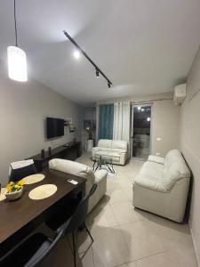 a living room with couches and a dining room table at Turdiu center apart in Tirana