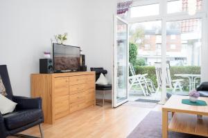a living room with a tv on a wooden dresser at Villa Olga Wohnung 3 in Grömitz