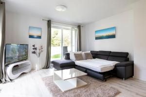a living room with a couch and a tv at Wohnung 2 in Haffkrug