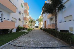 a cobblestone street between two apartment buildings at Appartement avec piscine dans une résidence fermée in Tangier
