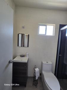 a bathroom with a toilet and a sink and a window at Casa 3 recamaras lavadora secadora NO límite de personas in Hermosillo