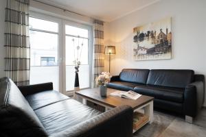 a living room with a couch and a table at Strandresidenz Vogelflug App 13 in Fehmarnsund