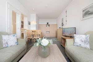 Una sala de estar con dos sofás y una mesa. en Haus Meeresblick Findling, en Kellenhusen