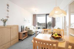 Una cocina y una sala de estar con mesa y sillas. en Haus Meeresblick Findling, en Kellenhusen