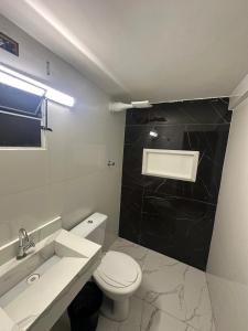 a bathroom with a white toilet and a sink at Hotel Marajá Bela Vista - Próximo ao Shopping Frei Caneca in Sao Paulo