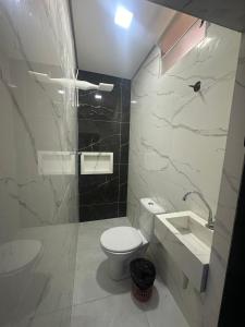 a bathroom with a white toilet and a sink at Hotel Marajá Bela Vista - Próximo ao Shopping Frei Caneca in Sao Paulo