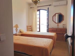 アルトゥーラにあるCasa da Praia - T3 em Alturaのベッドルーム1室(ベッド2台、鏡、ドレッサー付)