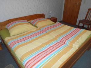 a large bed with a colorful striped blanket on it at Scheel I in Schlagsdorf