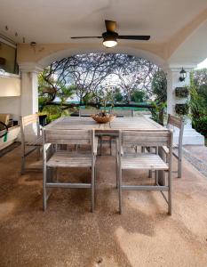ein Holztisch und Stühle auf einer Terrasse in der Unterkunft CASCADAS, Charming home great location with pool & garden in Cancún