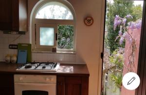 a kitchen with a stove top oven next to a window at Casetta Glicine in Ischia Town