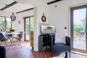 Una sala de estar con un televisor y una mesa. en Landhaus Auszeit, en Rüting
