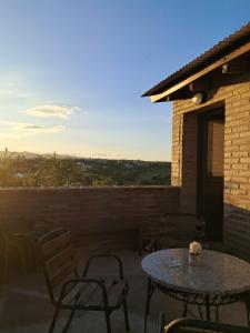 a table and chairs on a patio with a view at Terrazas al Golf in Alta Gracia