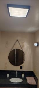 a bathroom with a sink and a mirror on the wall at Apto 3 Quartos com Suíte e 3 Banheiros em Guarapari in Guarapari