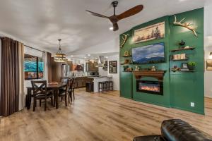 een woonkamer met een groene muur en een open haard bij Ponderosa Pines Cabin in Mountainaire