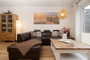 a living room with a couch and a table at Ferienhaus Salomons Sonne in Kellenhusen