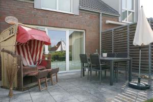 a patio with a table and chairs and an umbrella at Ferienhaus Salomons Sonne in Kellenhusen