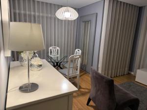 een woonkamer met een tafel en stoelen en een lamp bij MyHome Braga1 in Braga +9 foto's