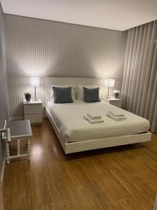 een slaapkamer met een groot bed en twee nachtkastjes bij MyHome Braga1 in Braga