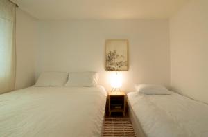 two beds in a small room with a light between them at Ahn-sik, 安息 in Seoul