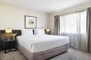 a bedroom with a large white bed and a window at Edit Auckland Greenlane in Auckland +11 photos