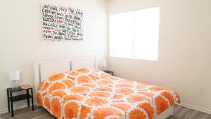 an orange bed in a white bedroom with a window at Spacious 2BR Townhouse - 3 Queens - Sleeps 8 in Redondo Beach +28 photos