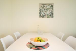 a bowl of fruit on a table with white chairs at Lange Wiese 16b in Dahme