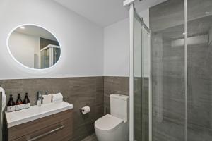 a bathroom with a toilet and a glass shower at Alpine Grandview Luxury Townhouse - Explore Wanaka in Albert Town +9 photos
