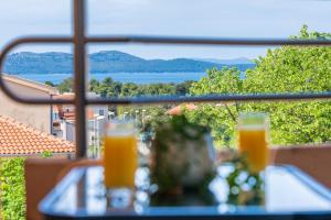 a table with two glasses of orange juice on a balcony at Apartment MARINA in Zadar