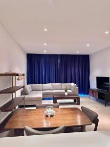 a living room with a couch and a table at Brand new apartmentWith a nice view balcony in Seeb