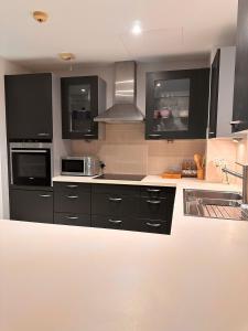 a kitchen with black cabinets and stainless steel appliances at Brand new apartmentWith a nice view balcony in Seeb