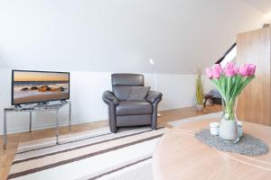 a living room with a chair and a television at Haus Hüttmann Sommerbrise in Gremsmühlen +29 photos