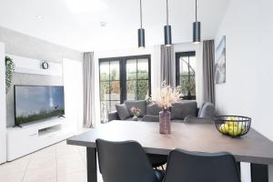 a living room with a dining table and a television at Haus Titania Wohnung 2 in Grömitz