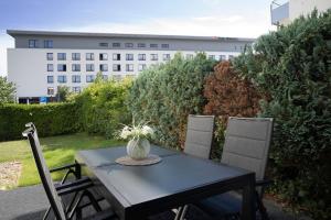 a black table and chairs on a patio with a building at Haus Titania Wohnung 2 in Grömitz