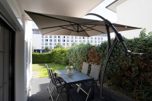 a table and chairs with an umbrella on a patio at Haus Titania Wohnung 2 in Grömitz