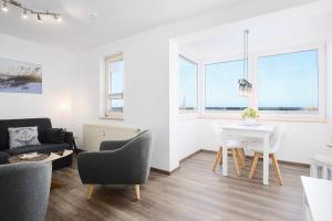 a living room with a white table and chairs at Promenade 27 Koje 23 in Stakendorfer Strand +25 photos