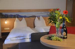 a hotel room with a bed and a table with flowers at Hotel Seiserhof & Seiseralm in Bernau am Chiemsee