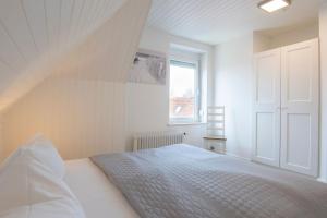 a white bedroom with a bed and a window at Seestraße 30a In der Mühle in Dahme +11 photos
