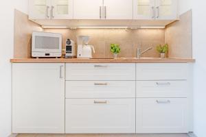 沙博伊茨Haus Meeresstrand BeachBude Scharbeutz的厨房配有白色橱柜和台面上的电脑