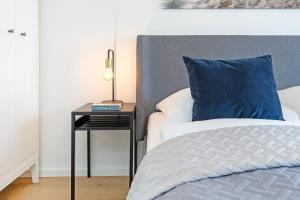 沙博伊茨Haus Meeresstrand BeachBude Scharbeutz的一张带蓝色枕头和边桌的床