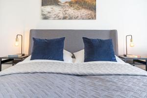 沙博伊茨Haus Meeresstrand BeachBude Scharbeutz的卧室里有一张带蓝色枕头的床 更多28张照片