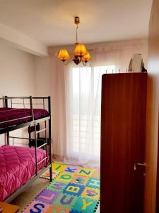 a bedroom with two bunk beds and a window at Tanger Beach Appartement en Face plage Houara Golf Resort in Dghaliyene