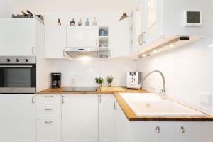 a kitchen with white cabinets and a sink at Haus Meeresblick Ankerplatz 84 in Kellenhusen
