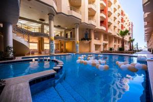 a large swimming pool in a building with a building at Casablanca Beach for families only in Hurghada