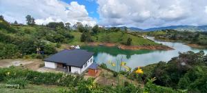 a small house on a hill next to a river at Finca Villa Glamping in La Pradera