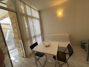 a small table and chairs in a room with a window at Dimora 69 in Lecce